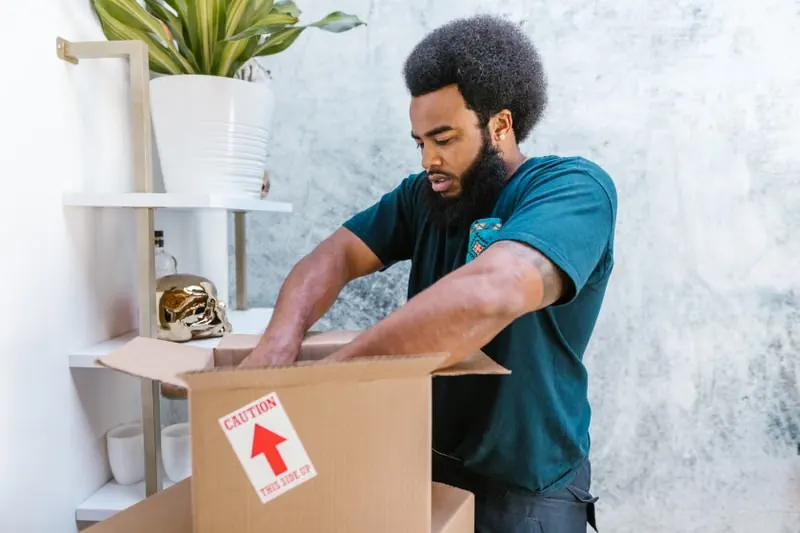 A mover packing a fragile item into a box