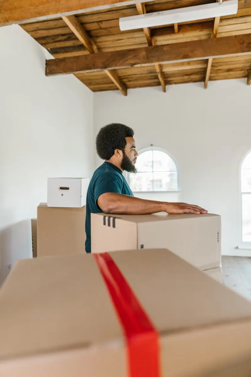 A worker moving boxes in a large empty room